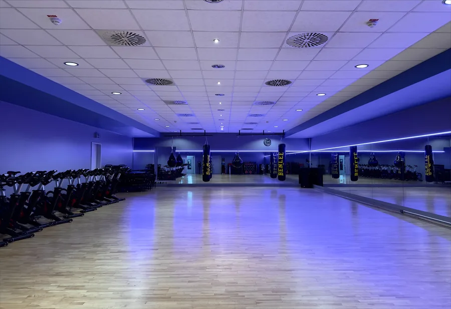 Kursraum im FTB Nürnberg mit Indoor-Cycling-Bikes und Boxsäcken in blauem Licht